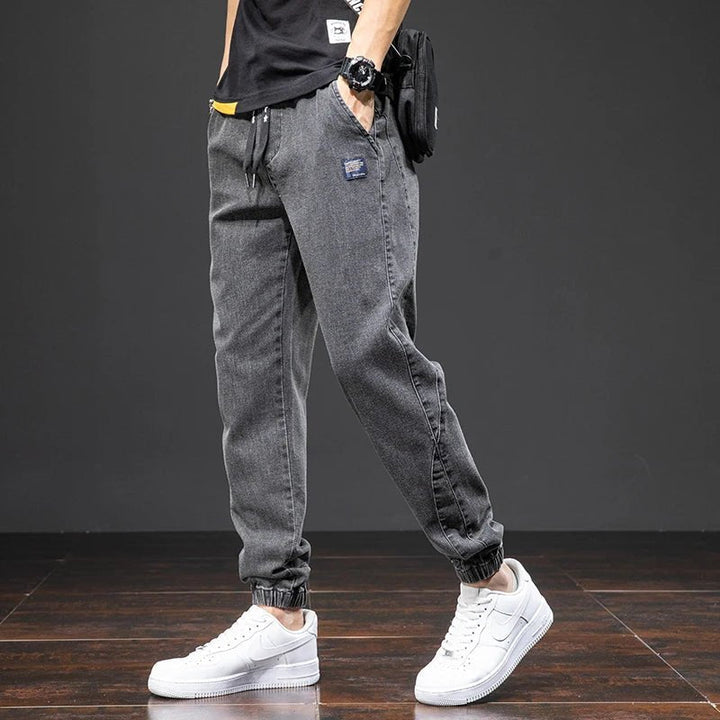 Comfortable men's blue denim joggers, featuring stretch fabric, elastic waistband, and a relaxed, casual fit.