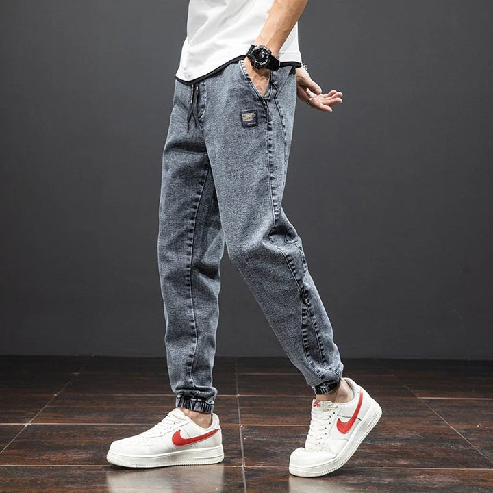 Versatile blue stretch denim joggers for men; ideal everyday pants with an elastic waist & modern tapered design.