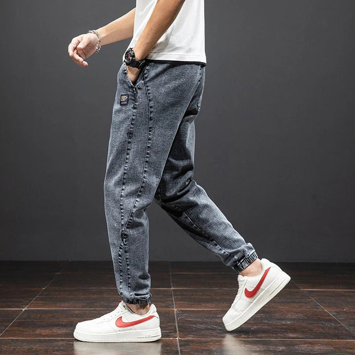 Men's casual blue denim joggers with ultimate stretch comfort, an elastic waist, and a stylish tapered leg.