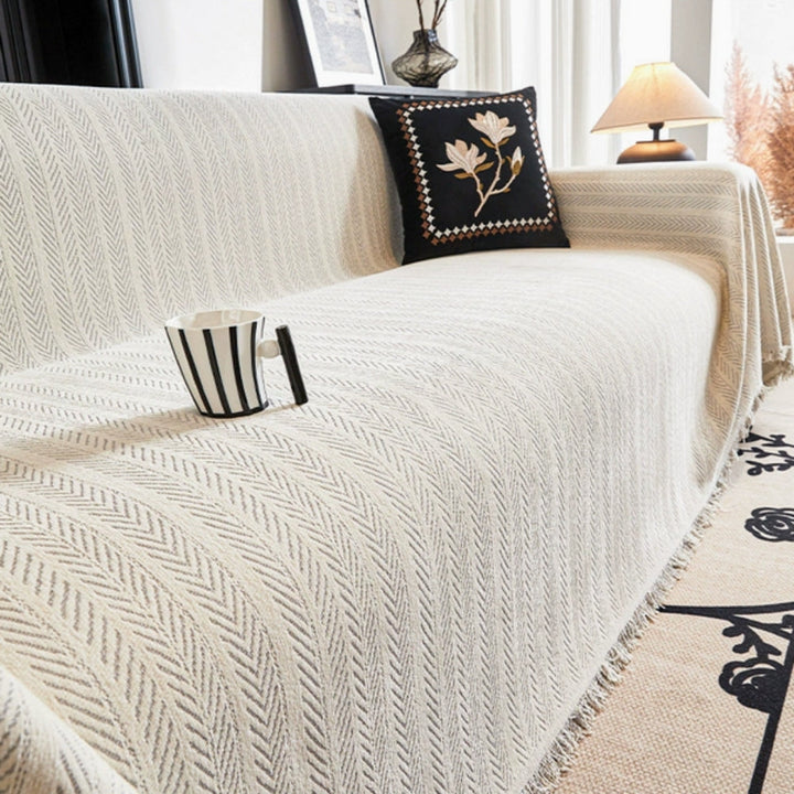 Washable couch cover in soft chenille, featuring a stylish herringbone design and fringe.