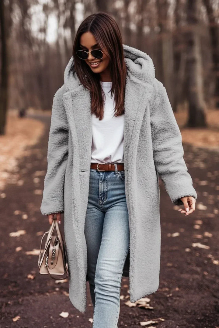 Women's warm oversized black hooded winter coat, featuring stylish button closure. Cozy long-sleeve fall outerwear.