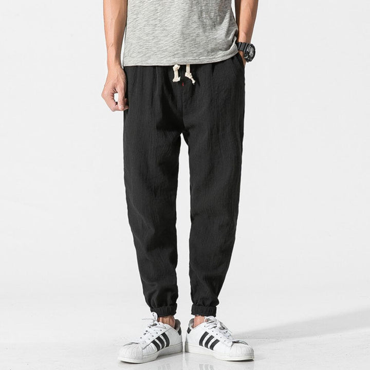 Comfortable men's tapered linen pants with elastic cuffs, designed for a relaxed everyday fit.
