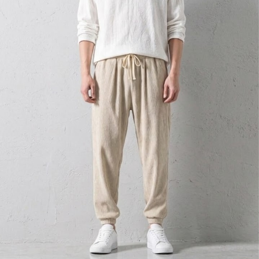 Detail shot of men's comfortable tapered linen joggers, showcasing drawstring waist and elastic cuffs.