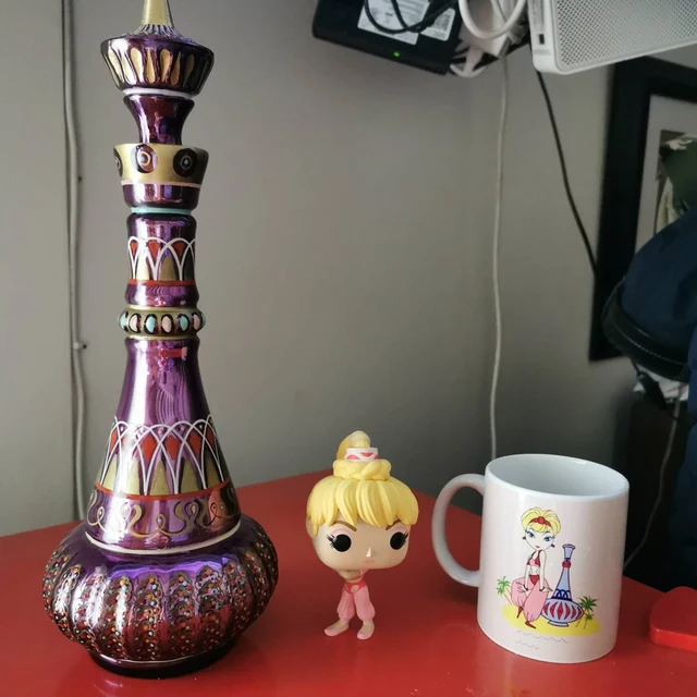 Rich purple hand-blown glass art genie bottle, enchanting fantasy decor.