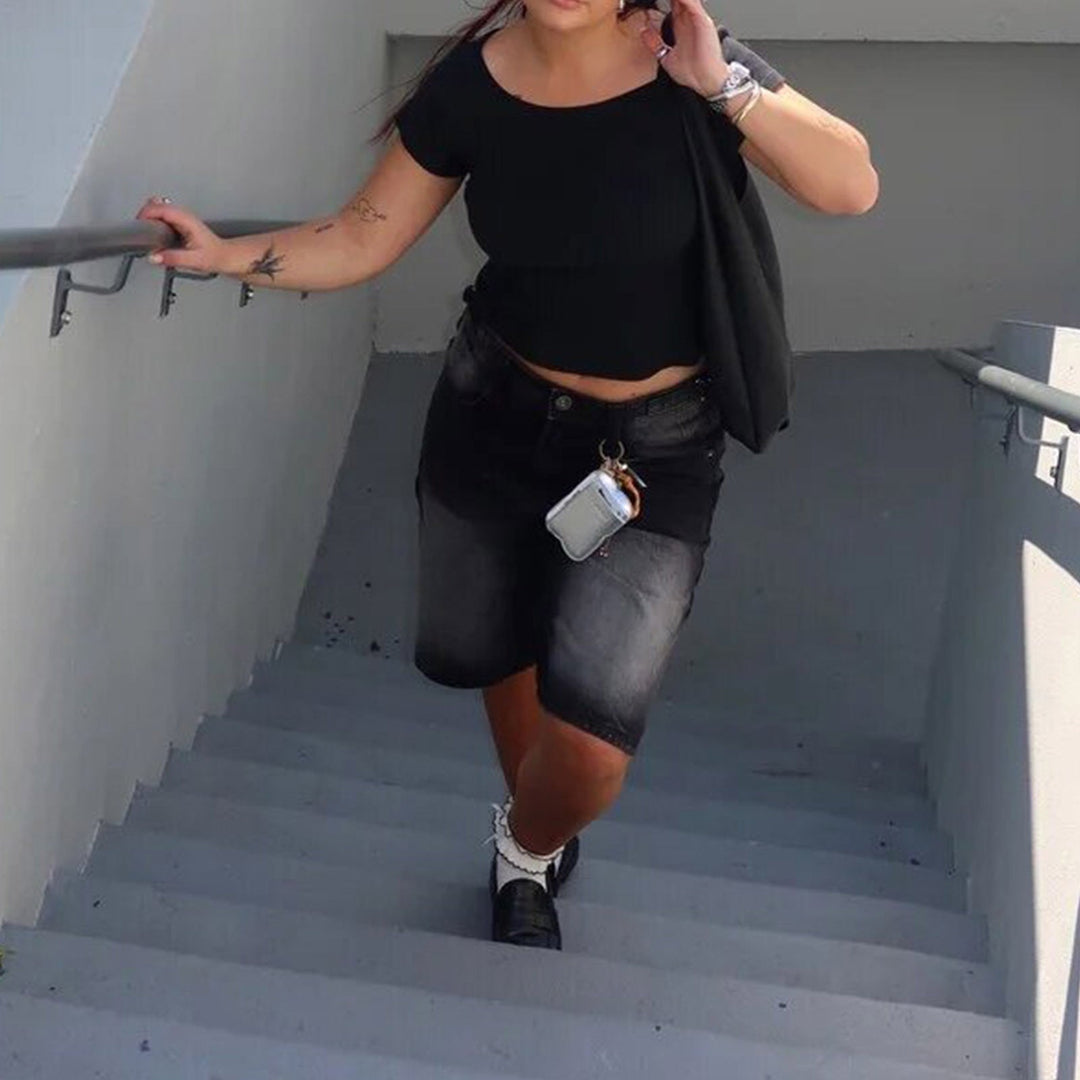 Black high-waisted relaxed fit women's denim shorts, knee-length for versatile everyday style.