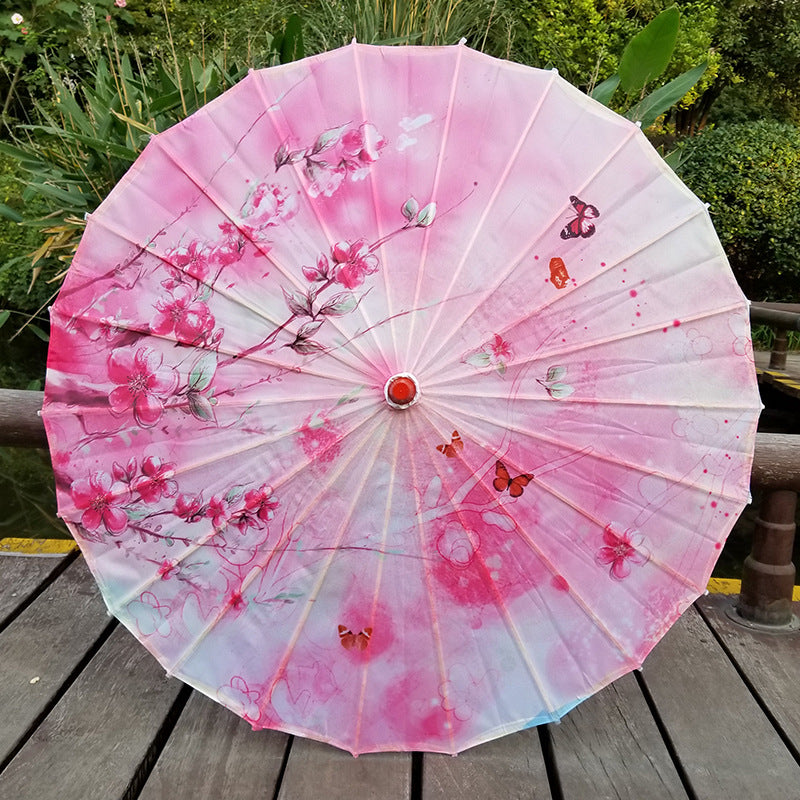 Elegant Japanese UV protection parasol with cherry blossom design & bamboo handle for summer sun.