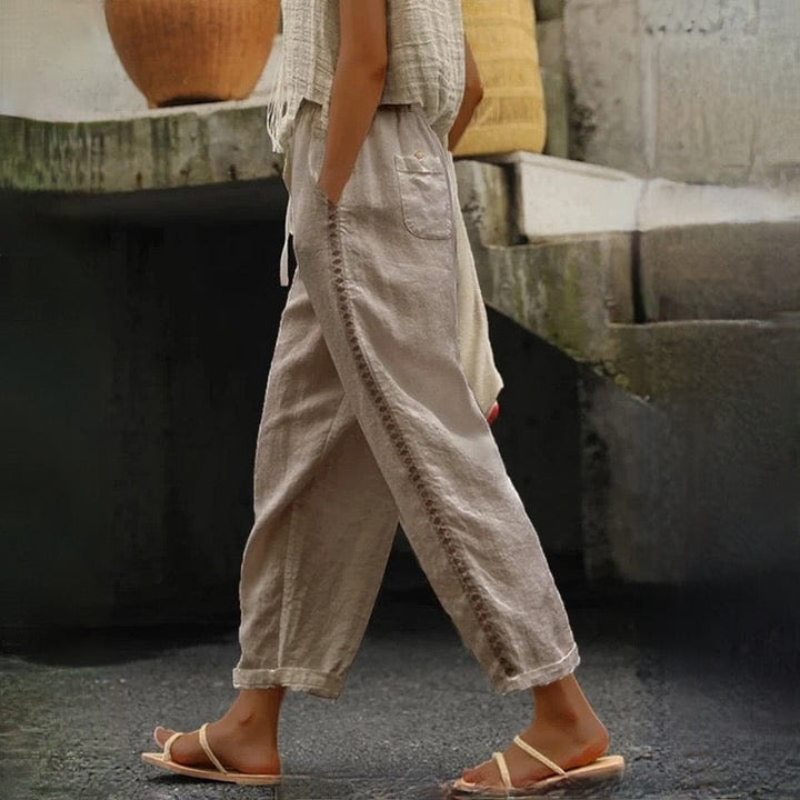 Relaxed fit women's linen cropped pants featuring stylish eyelet trim and a flexible elastic waist for comfort.