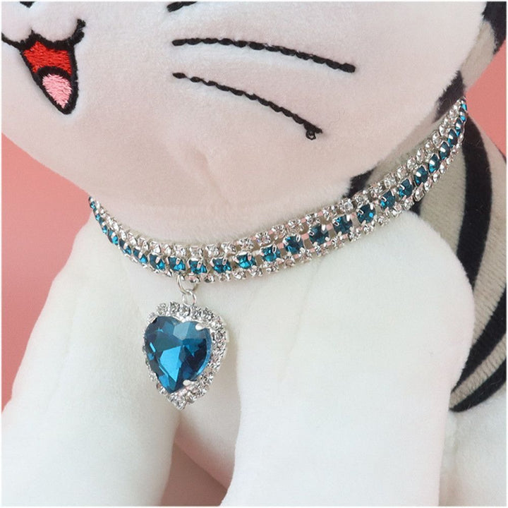 Shimmering rhinestone cat collar with a reflective heart pendant, perfect for small pets.