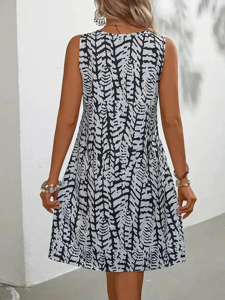 Woman wearing a casual yet elegant graphic print fluid summer dress, ideal for warm weather comfort.