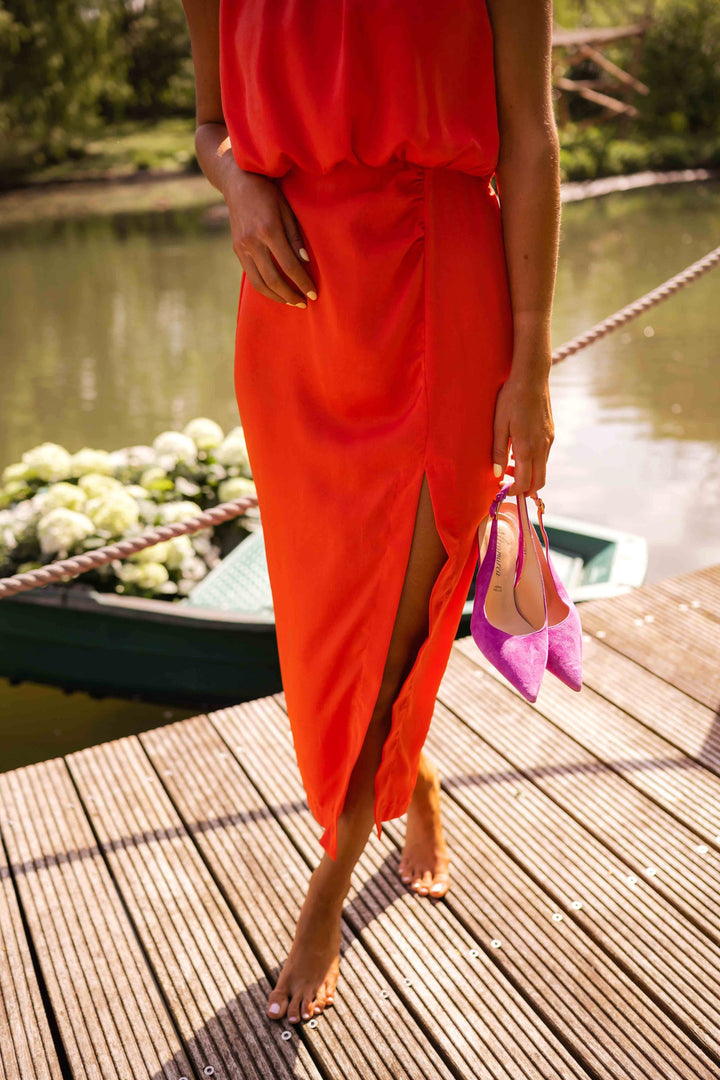 Women's high neck sleeveless midi dress with a tasteful side slit. Elegant summer fashion in orange.