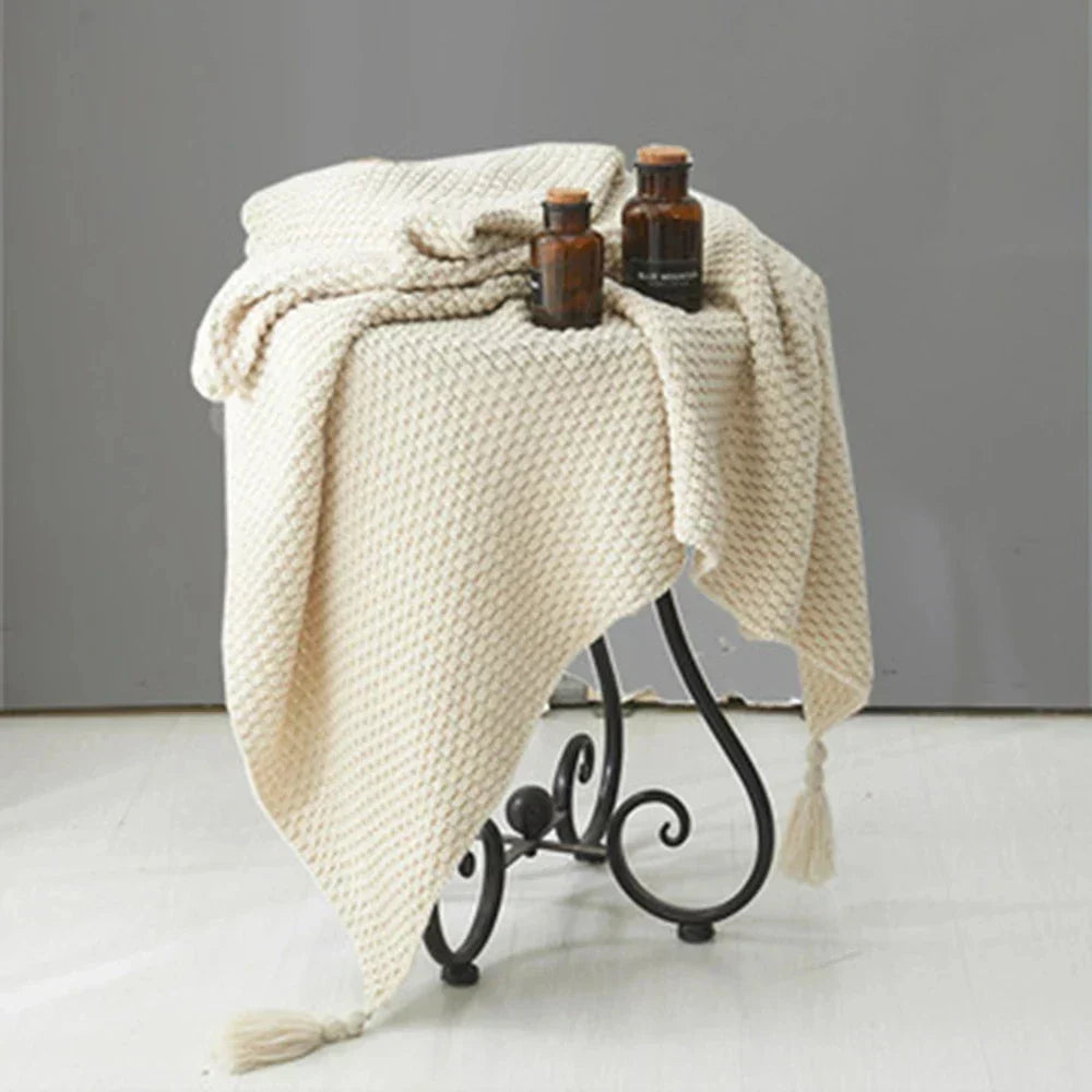Versatile knitted wool blanket with tassels, perfect for living room or bedroom warmth.