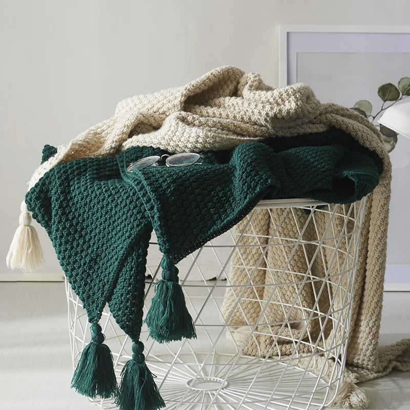 Knitted wool blanket with tassels, perfect for a cozy living room or bedroom.