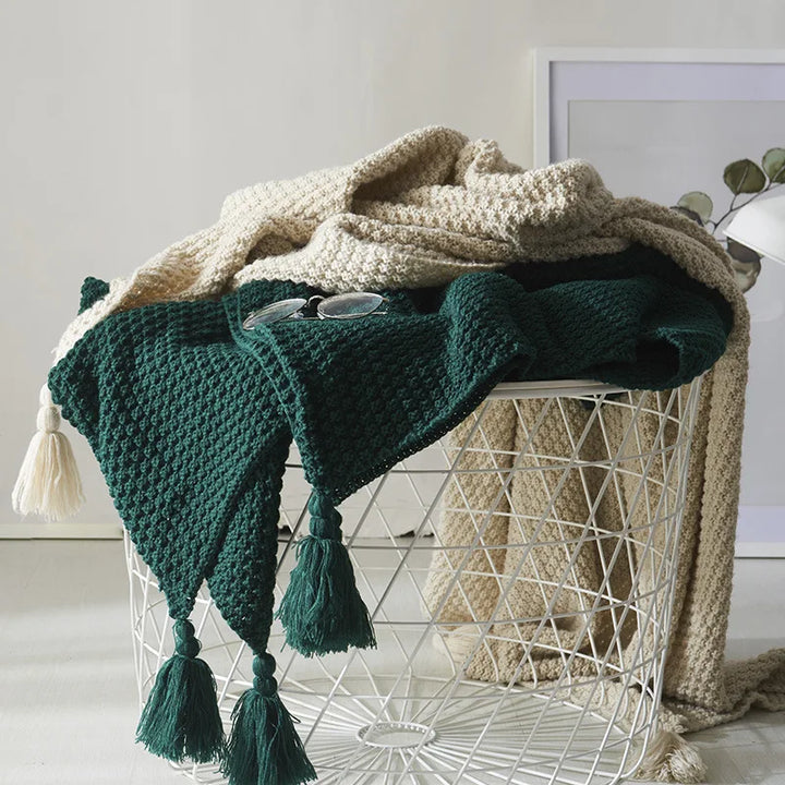 Knitted wool blanket with tassels, perfect for a cozy living room or bedroom.