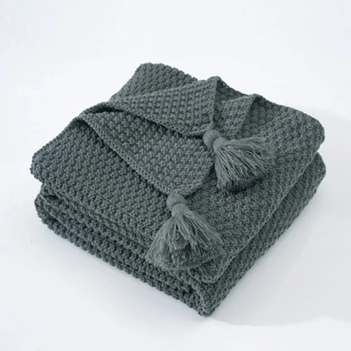 Premium wool blend knitted blanket with tassels, comfortable & chic for cozy home use.
