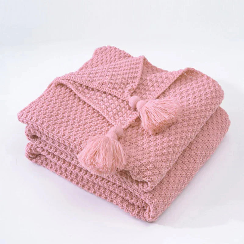 Decorative knitted blanket, gray wool with elegant tassels for ultimate home comfort.