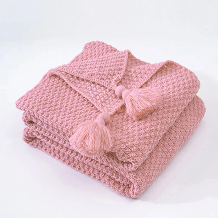 Decorative knitted blanket, gray wool with elegant tassels for ultimate home comfort.
