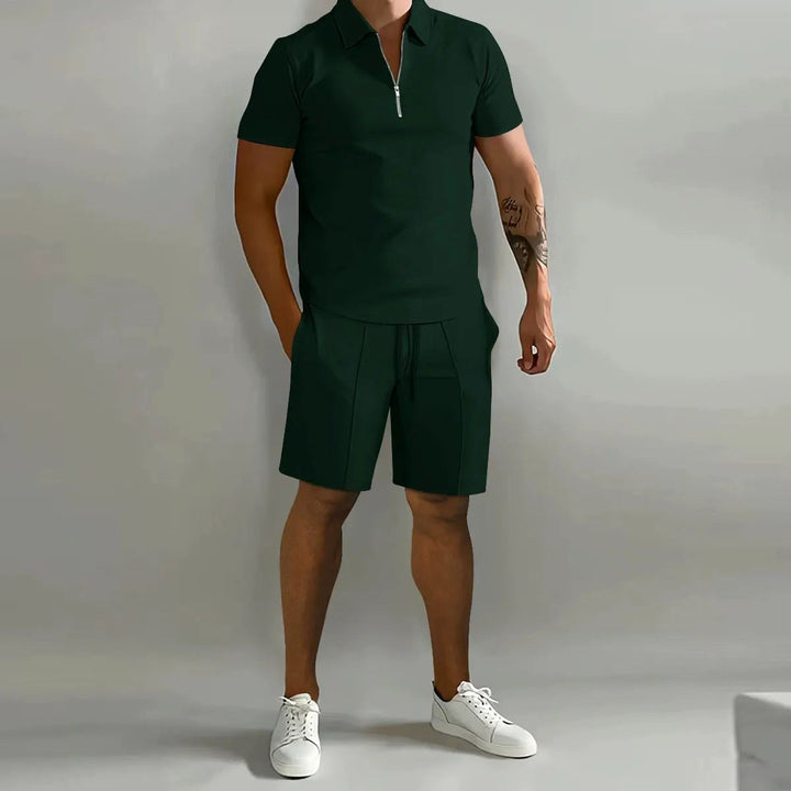 Man relaxing comfortably in a men's zip-neck polo & drawstring shorts lounge wear set, summer fashion.