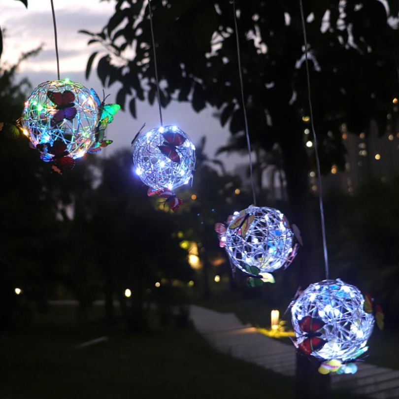 Waterproof solar butterfly LED light, illuminating a patio, automatic dusk-to-dawn outdoor garden decor lamp.