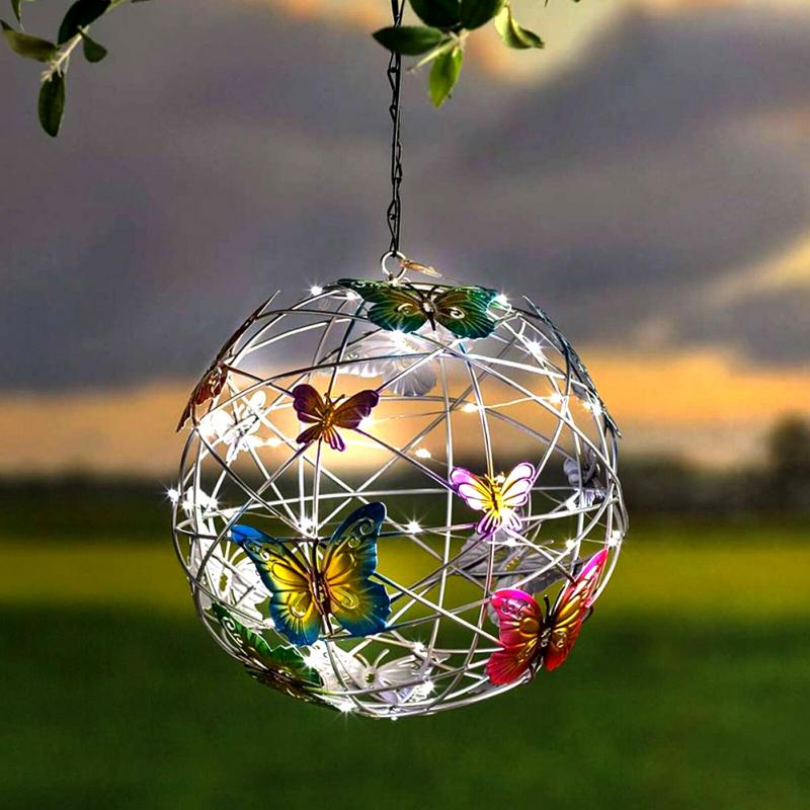 Solar-powered butterfly LED light, glowing in a garden at dusk, perfect eco-friendly patio decor & outdoor lighting.