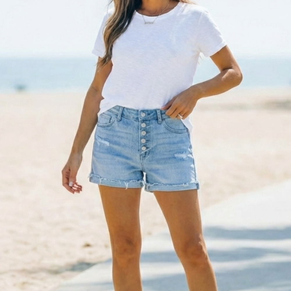 Casual and trendy women's light blue jorts with a classic button fly, ideal for warm-weather fashion.