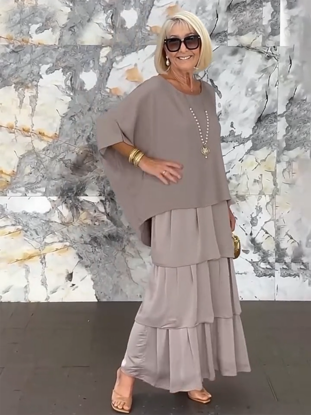 Women's occasion dress with stylish tiered ruffles and flowing batwing sleeves.