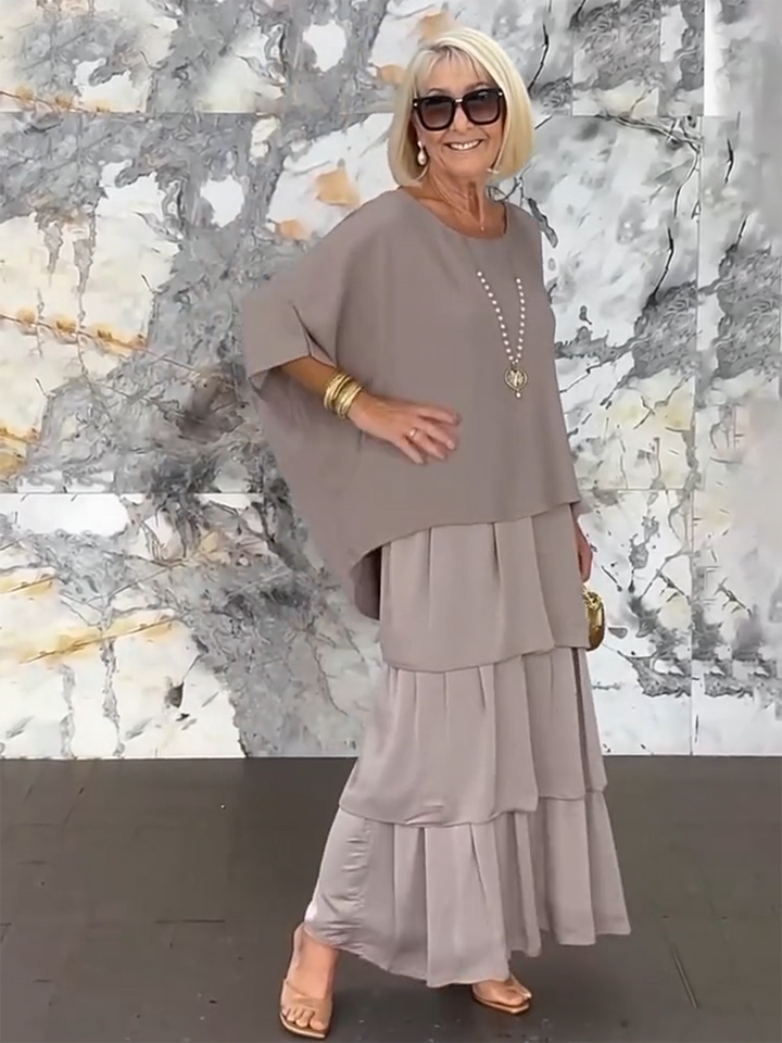 Women's occasion dress with stylish tiered ruffles and flowing batwing sleeves.