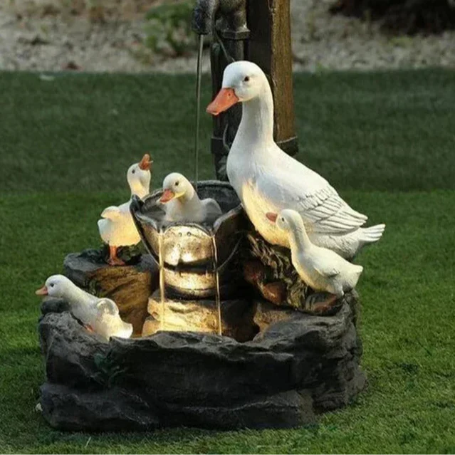 Outdoor solar fountain with LED light, featuring charming duck or squirrel figures. Perfect garden water feature.
