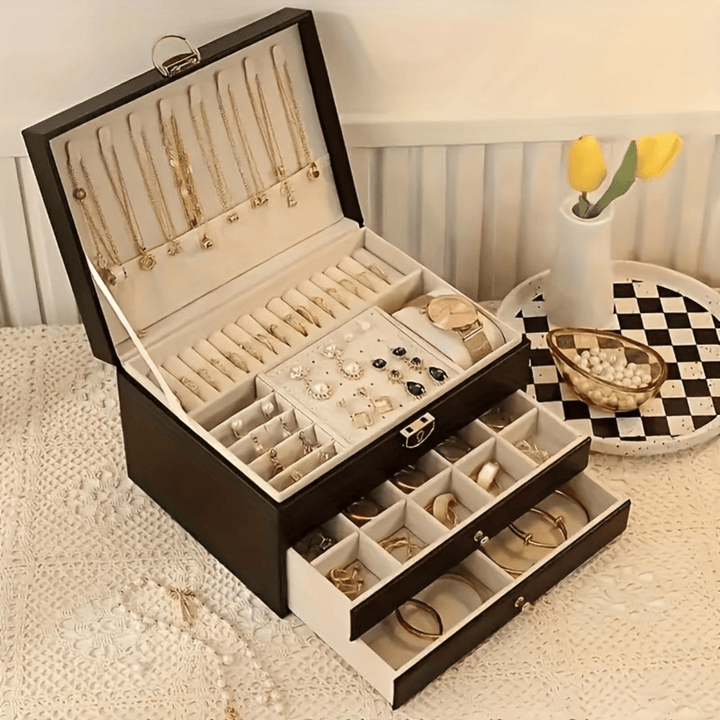 Open luxury green jewelry organiser box, displaying compartments for rings, necklaces, & bracelets.