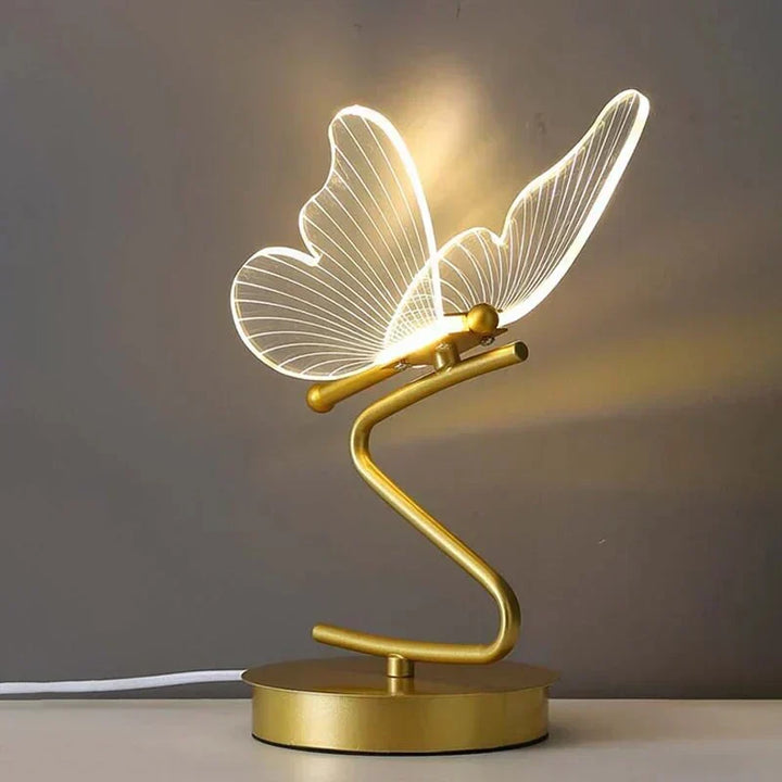 Close-up of elegant gold butterfly detail on a luxury LED table lamp, enhancing modern home decor with warm light.