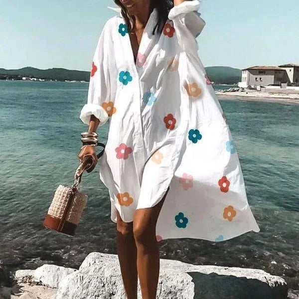 Women's white flowing shirt dress styled casually for the city. Chic, versatile & comfortable summer fashion.