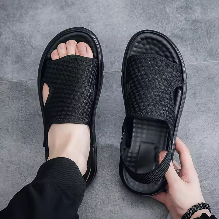 Men's black woven orthopedic sandals with adjustable strap, offering arch support & cushioned sole for comfort.