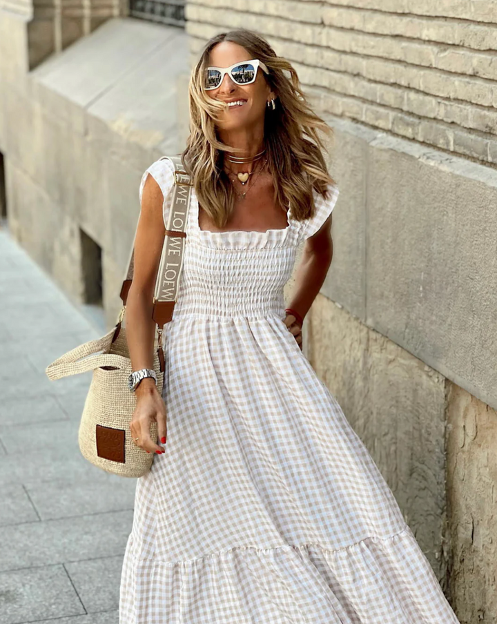 Red gingham women's maxi dress, smocked bodice, and flutter sleeves. Ideal for parties or vacation fashion.