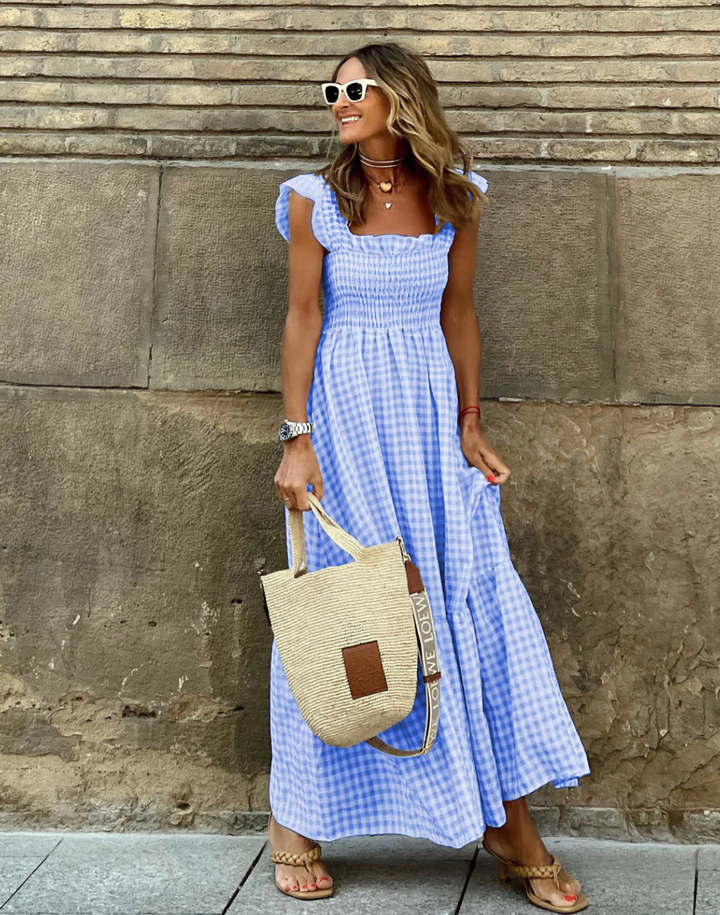 Flowy tiered gingham maxi dress, smocked and styled with flutter sleeves for women's casual or party wear.