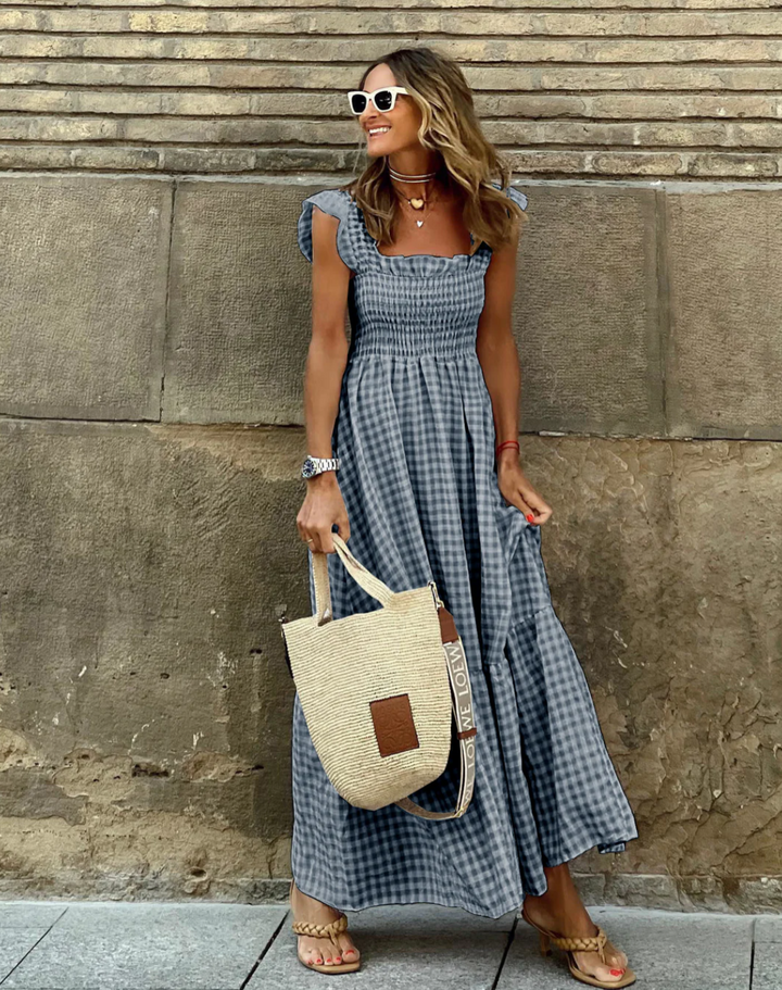 Comfortable smocked gingham maxi dress for women, with flutter sleeves; a versatile summer and vacation style.