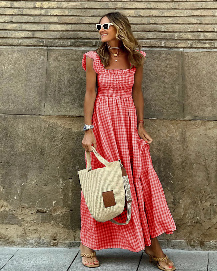 Elegant women's gingham maxi dress with smocked bodice, flutter sleeves, and a flattering flowy tiered skirt.