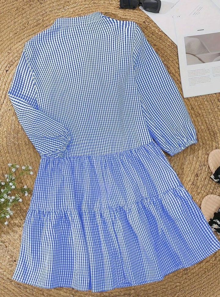 Chic women's tiered mini dress with playful puff sleeves, a stylish and flowy gingham summer outfit.