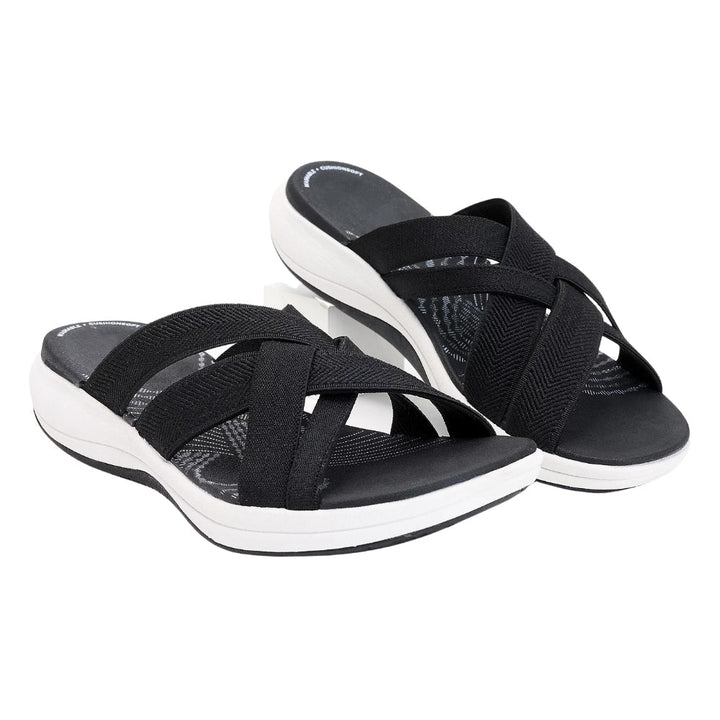 Stylish women's slip-on sandals with cushioned cross-straps, perfect for summer comfort.