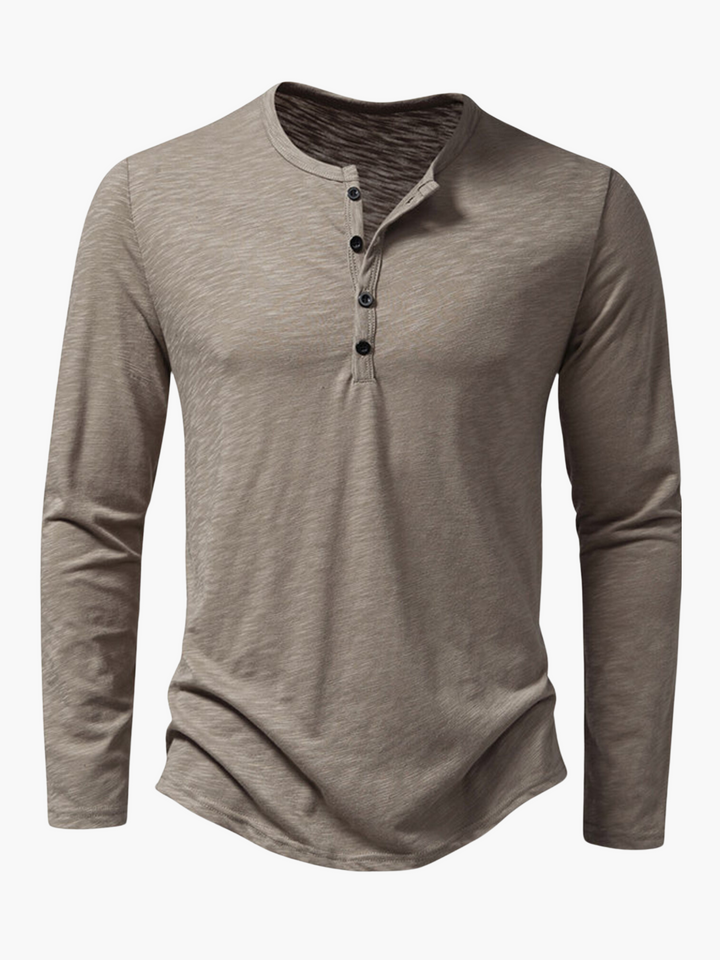 Detailed shot of the fabric and stitching on a men's henley shirt.
