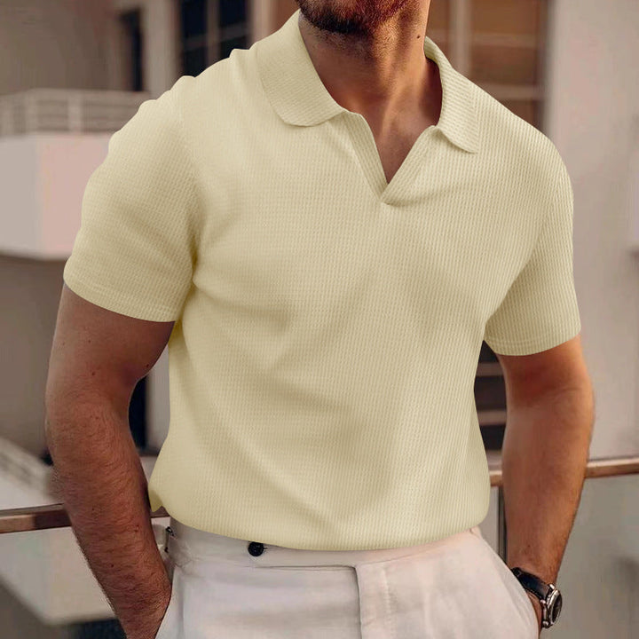 Close-up of the breathable fabric on a men's classic fit polo shirt.