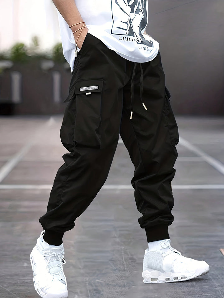 Men's relaxed fit cargo pants with drawstring waist, multiple utility pockets, and ankle cuffs for casual style.