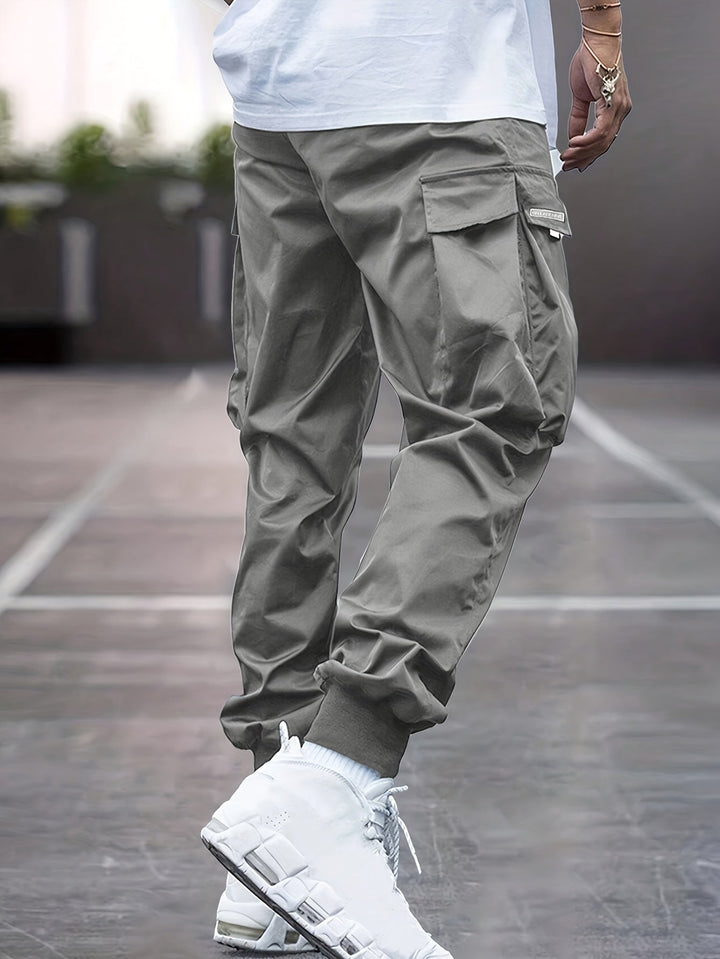 Men's multi-pocket utility cargo pants in a relaxed fit, featuring an adjustable drawstring and practical ankle cuffs.