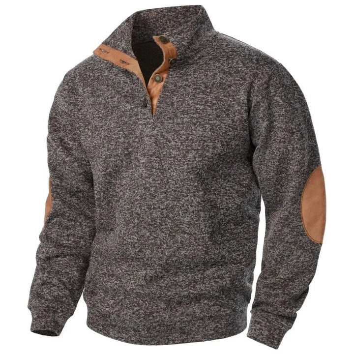 Man wearing a grey V-neck sweatshirt, showcasing casual outdoor style.