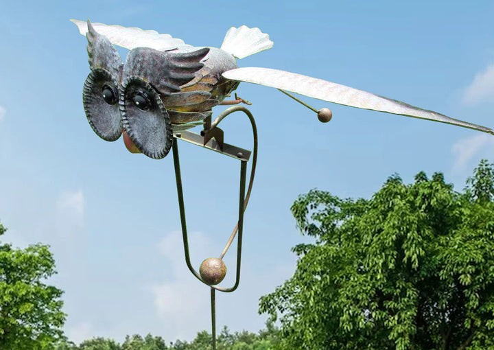 Close-up of a metal garden windmill sculpture showing intricate rotating wings.