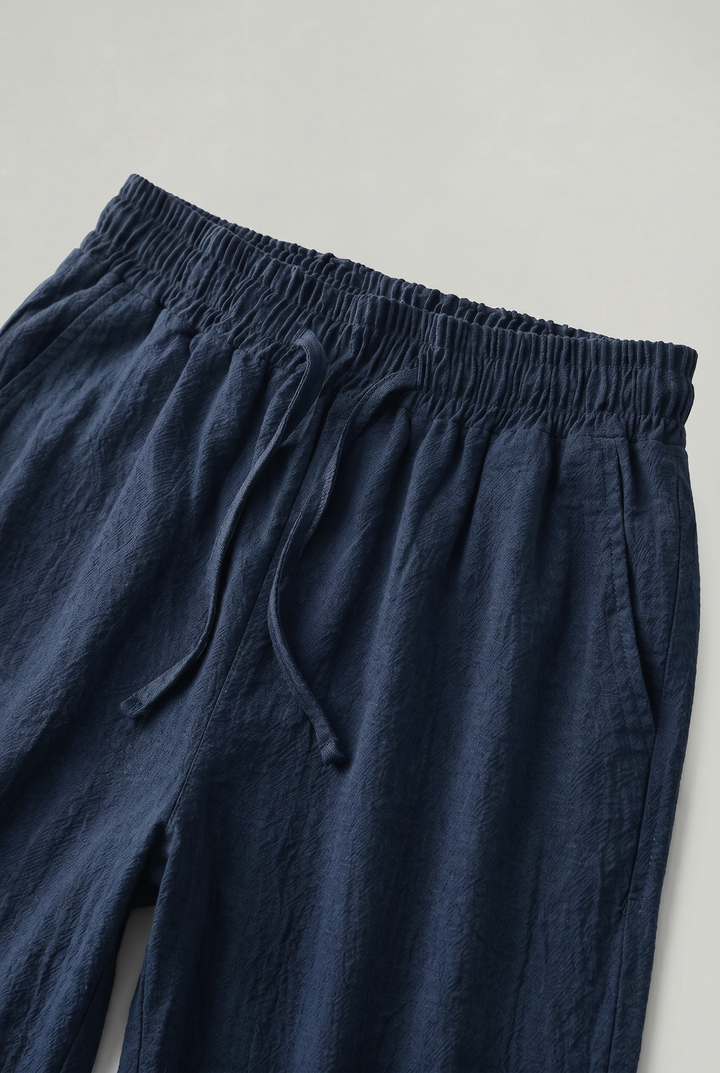 Comfortable navy men's linen shorts, effortless relaxed fit, knee-length, featuring a practical drawstring waist.