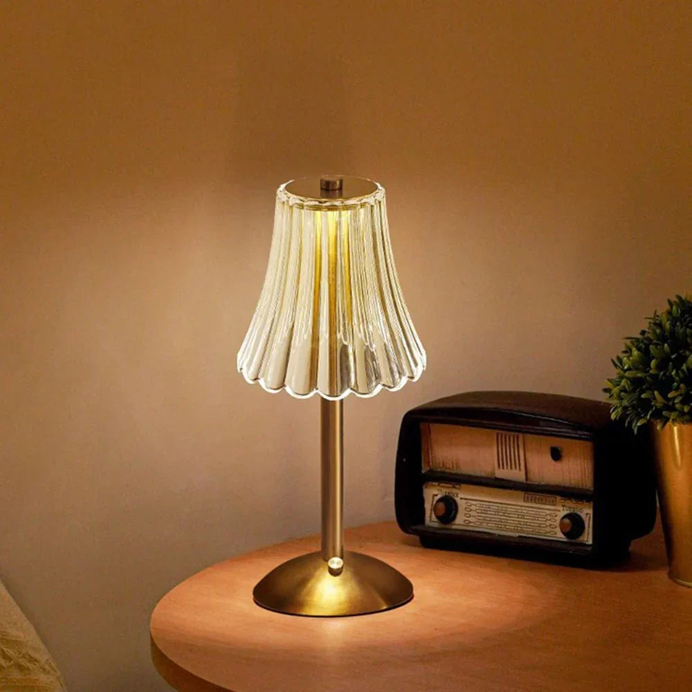 Dimmable LED crystal table lamp, providing warm ambient light, with a polished gold base.