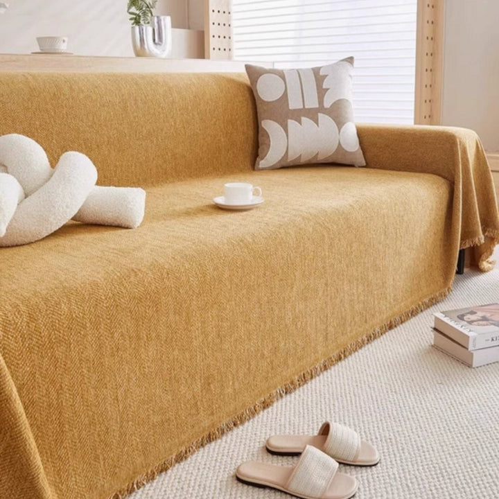 Close-up of a stylish, modern knitted throw blanket texture, adding warmth and a chic home accent to any living room sofa.