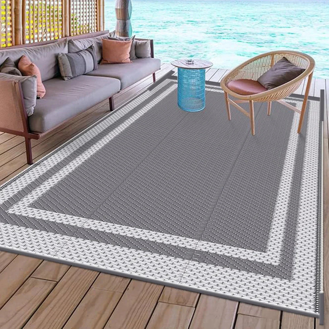 Reversible modern gray outdoor rug, rectangular patio mat with geometric design for camping or deck.