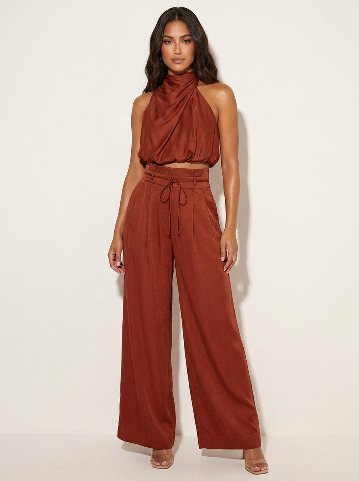 Fashionable women's party attire: elegant halter neck, wide-leg pants matching suit set.