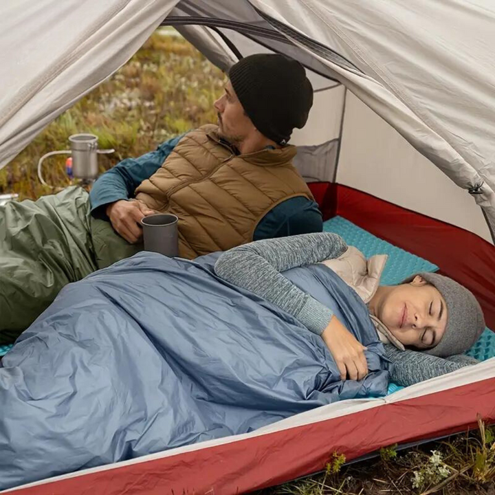 Warm green sleeping bag, ideal for camping. Compact and lightweight for comfortable outdoor nights.