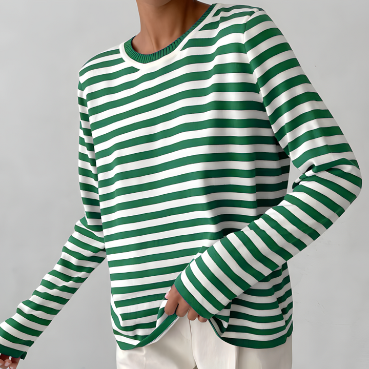 Women's striped knit sweater paired with jeans. Classic long sleeve crew neck pullover for effortless casual fashion.